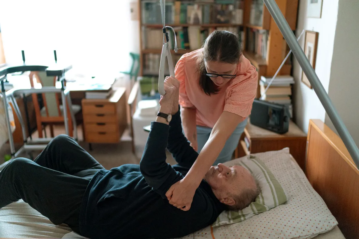 caregiver helping elderly man
