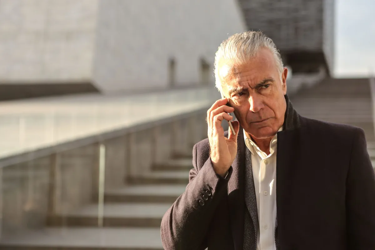 elderly man on phone looking concerned