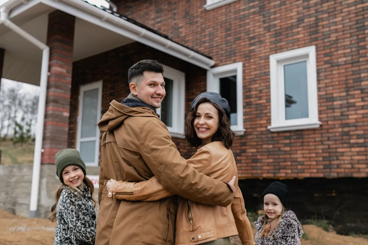 happy family in front of new home