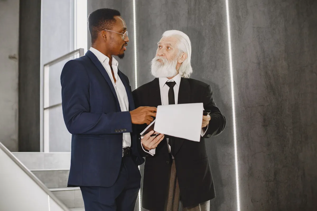 older man mentoring younger professionals