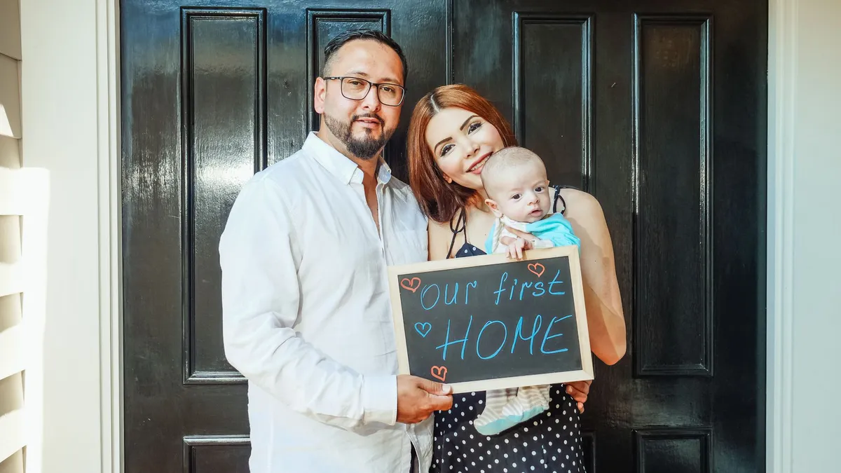 happy family in front of new home